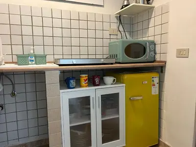 a kitchen with a yellow refrigerator and a microwave at Glicine House in Palermo