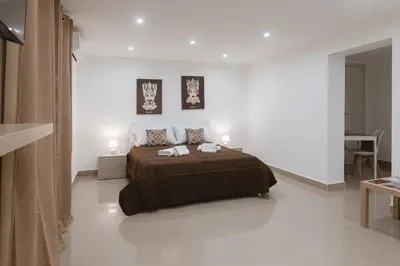 a bedroom with a large bed in a white room at Dimora del Moro in Palermo