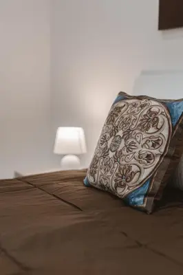 a pillow sitting on a bed next to a lamp at Dimora del Moro in Palermo