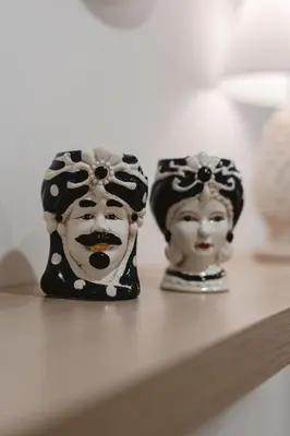 two masks sitting on top of a shelf at Dimora del Moro in Palermo