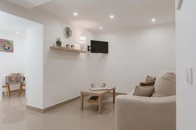 a white living room with a couch and a table at Dimora del Moro in Palermo