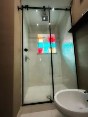 a glass shower in a bathroom with a sink at Allalbergheria Apartment in Palermo