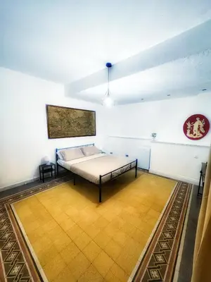 a bedroom with a bed and a painting on the wall at Allalbergheria Apartment in Palermo