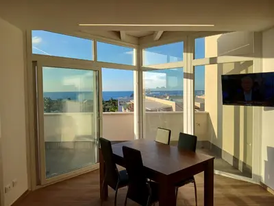 a dining room with a table and a large window at HolidayHouse Belvedere in Terrasini