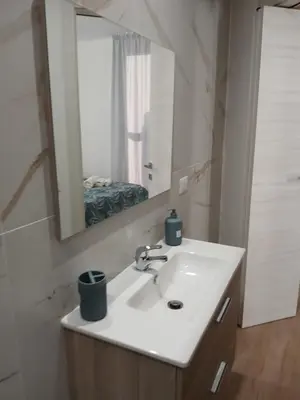 a bathroom with a white sink and a mirror at HolidayHouse Belvedere in Terrasini