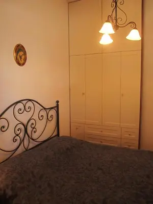 a bedroom with a bed and a closet and lights at Oasi del Sole- sun and sea - Casa Xenia in San Vito lo Capo