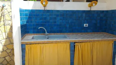 a kitchen with blue tiles and a sink at Oasi del Sole- sun and sea - Casa Xenia in San Vito lo Capo