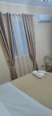 a bedroom with a bed with a window with curtains at Perla del Mare in Trappeto