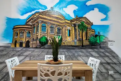 a room with a table and a painting of a building at MennulaMia in Palermo