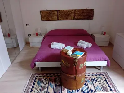 a bedroom with a bed with purple sheets and a barrel at Ballarò room in Palermo