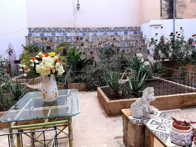 a vase of flowers sitting on a glass table at Ballarò room in Palermo