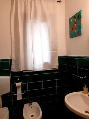 a bathroom with a toilet and a sink and a window at Ballarò room in Palermo