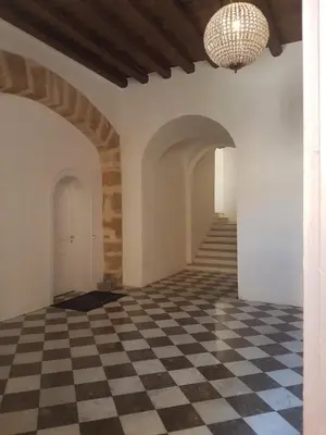 a hallway with a checkered floor and a chandelier at Ballarò room in Palermo