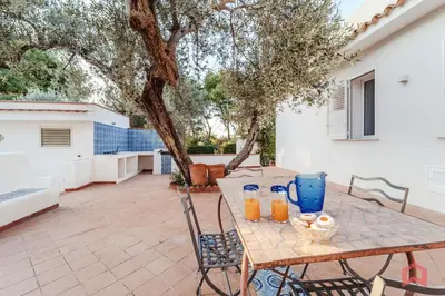 a table with drinks on it on a patio at Grande e Luminosa Villa con Piscina vicino al Mare in Terrasini