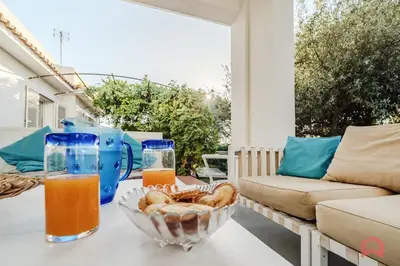 a table with two glasses of orange juice and a bowl of bread at Grande e Luminosa Villa con Piscina vicino al Mare in Terrasini