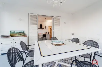 a dining room with a white table and chairs at Grande e Luminosa Villa con Piscina vicino al Mare in Terrasini