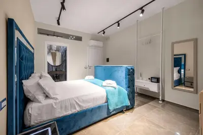 a bedroom with a blue bed and a mirror at D'ossuna66 Aquarium in Palermo