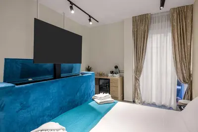 a bedroom with a blue bed with a tv on the wall at D'ossuna66 Aquarium in Palermo