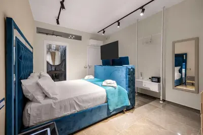a bedroom with a blue bed and a mirror at D'ossuna66 Aquarium in Palermo