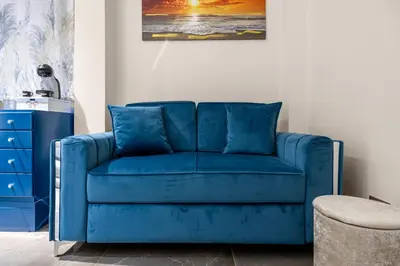 a blue couch in a living room with a painting at D'ossuna66 Classic in Palermo