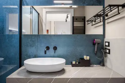 a bathroom with a white tub and blue wall at D'ossuna66 Classic in Palermo