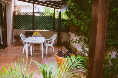 a white table and chairs on a patio at Oasi del Sole - sun and sea -Casa Colombo in San Vito lo Capo