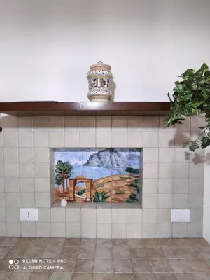 a tile wall with a painting of a lighthouse at Oasi del Sole - sun and sea -Casa Colombo in San Vito lo Capo