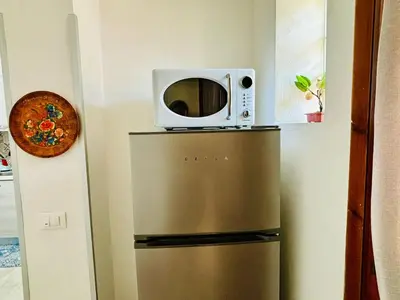a microwave sitting on top of a refrigerator at MaxMondello in Palermo