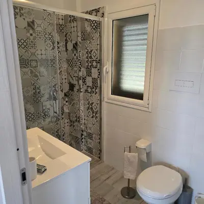 a bathroom with a toilet and a sink and a shower at Villa Orlando in Trabia