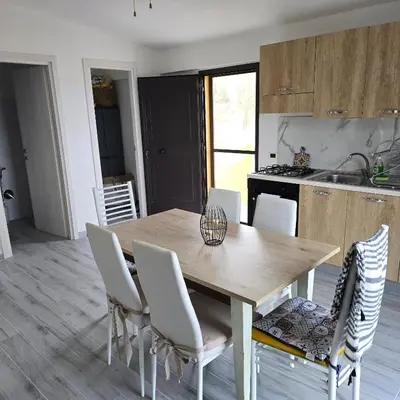a kitchen and dining room with a wooden table and chairs at Villa Orlando in Trabia