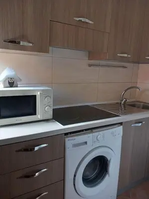a kitchen with a washing machine and a microwave at Piliero room in Palermo