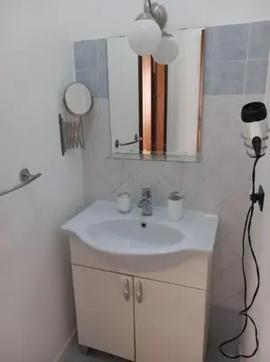 a bathroom with a white sink and a mirror at Piliero room in Palermo