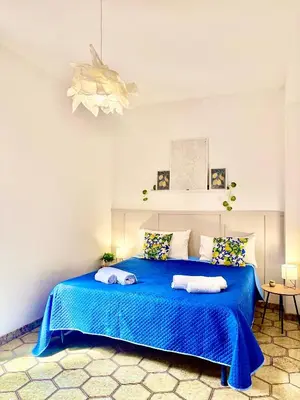 a bedroom with a blue bed with towels on it at Michelle Holiday House in Castellammare del Golfo