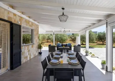 a swimming pool with a table and chairs next to it at Villa Degli Ulivi in Partinico