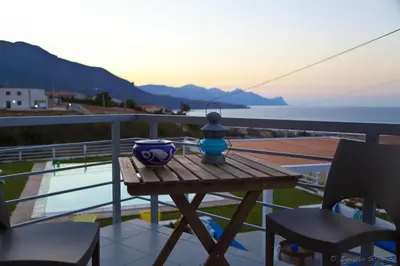 a table on a balcony with a view of the ocean at Casa Azul in Castellammare del Golfo
