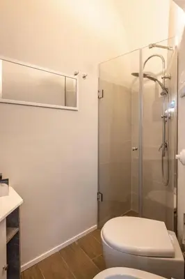 a bathroom with a toilet and a glass shower at Dimore D'amare in Palermo