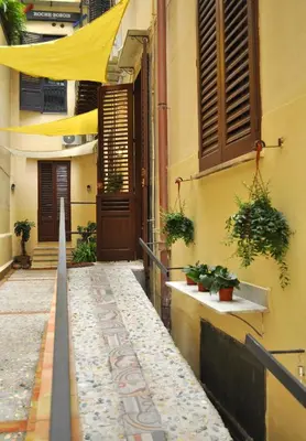a building with a yellow canopy over a walkway at Soste Normanne in Palermo