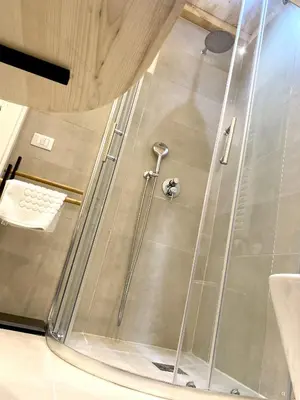 a shower with a glass door in a bathroom at Soste Normanne in Palermo