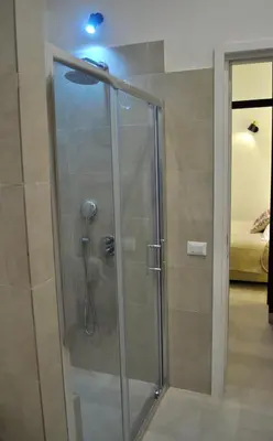 a shower with a glass door in a bathroom at Soste Normanne in Palermo