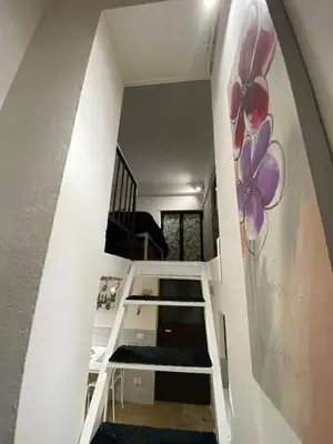 a staircase in a house with a painting on the wall at Little House in Palermo