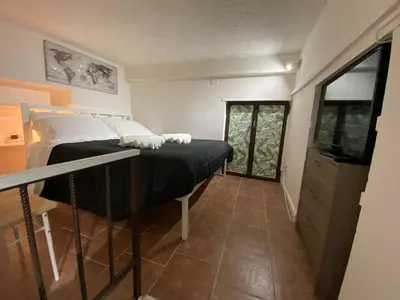 a bedroom with a bed with black sheets and white pillows at Little House in Palermo