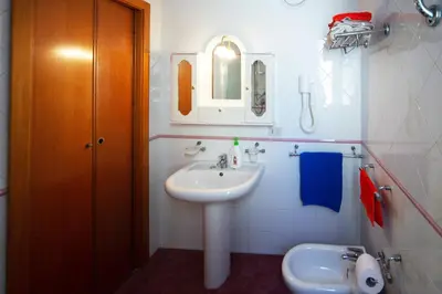 a white bathroom with a sink and a mirror at My House Holiday Apartment in Palermo