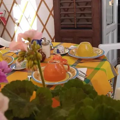 a table with plates of tea sets on it at B&B SoleLuna della Solidarietà in Palermo