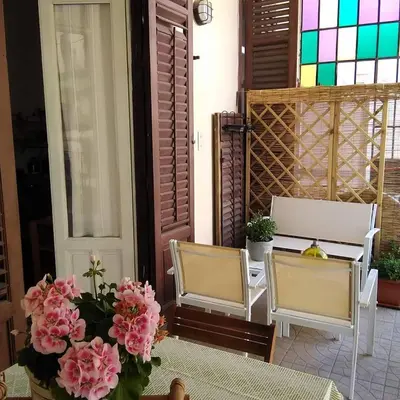a room with two chairs and a table with flowers at B&B SoleLuna della Solidarietà in Palermo