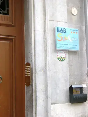a sign on the side of a building with a pay phone at B&B SoleLuna della Solidarietà in Palermo