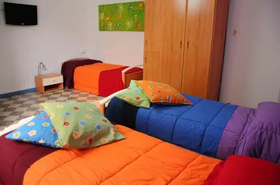 a room with two beds with colorful pillows at B&B SoleLuna della Solidarietà in Palermo