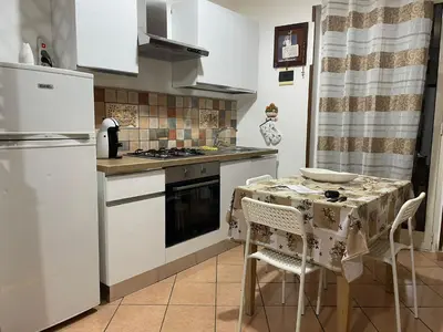 a kitchen with a table and a refrigerator at Casa Vacanze Corale in Palermo
