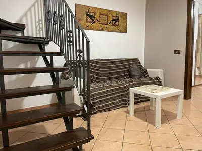 a living room with a staircase and a couch at Casa Vacanze Corale in Palermo
