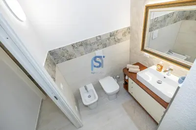 a bathroom with a white toilet and a sink at Villa Irene Deluxe in Campofelice di Roccella