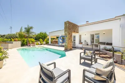 a backyard with a swimming pool and patio furniture at Villa Irene Deluxe in Campofelice di Roccella